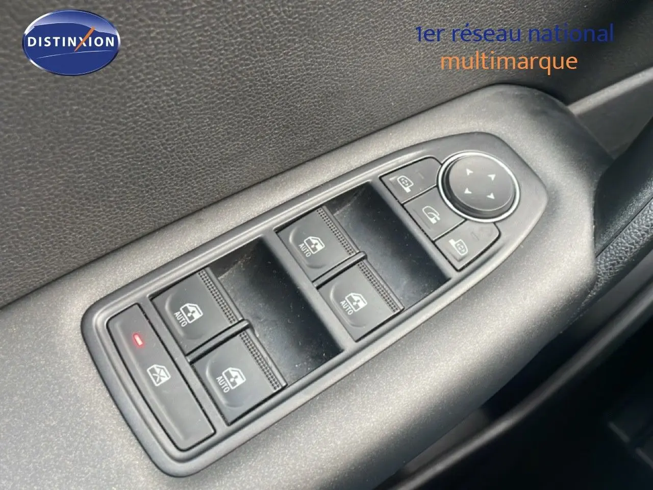 Gros plan sur les commandes des vitres électriques côté conducteur d’un Renault Captur gris Cassiopée métal.