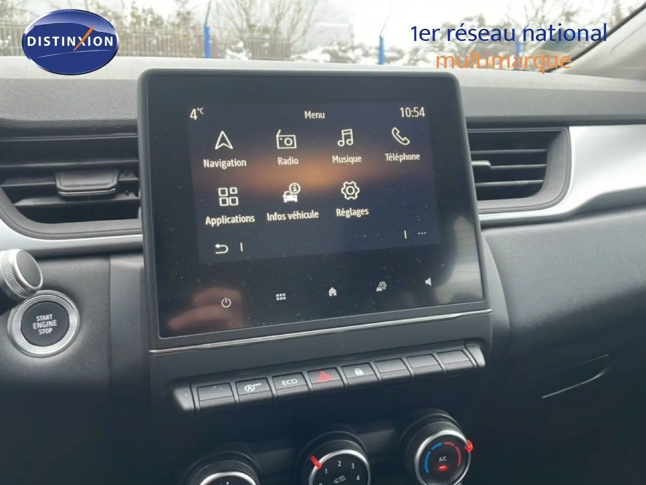 Vue intérieure centrée sur l'écran tactile multimédia et la console centrale du Renault Captur gris Cassiopée 2020.
