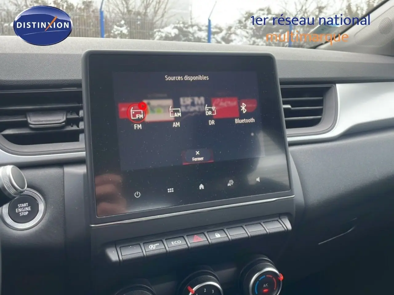 Vue intérieure centrée sur l'écran tactile multimédia et la console centrale du Renault Captur gris Cassiopée métal.