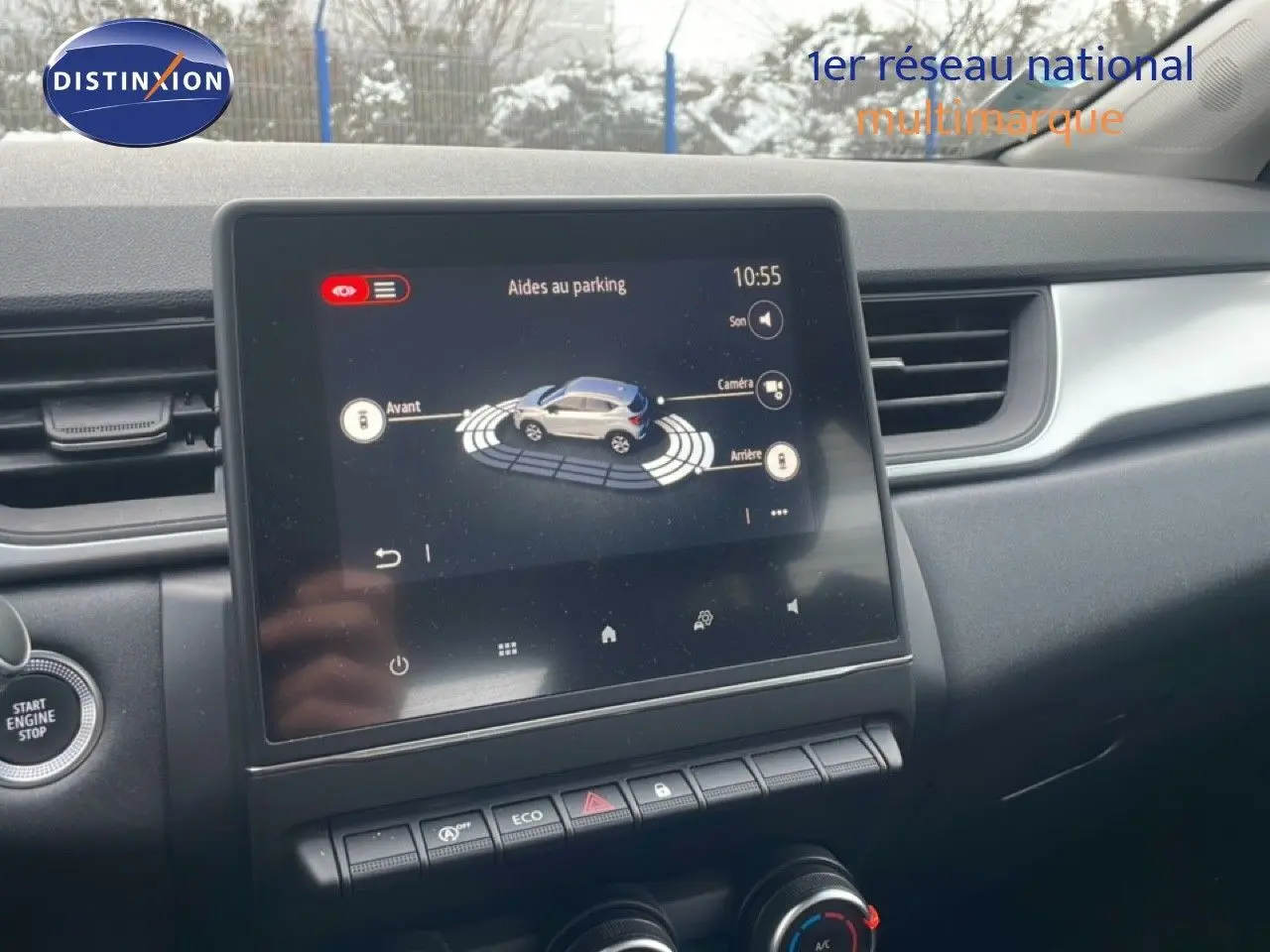 Vue intérieure centrée sur l'écran tactile du tableau de bord du Renault Captur gris cassiopée métal, affichant l'aide au parking.