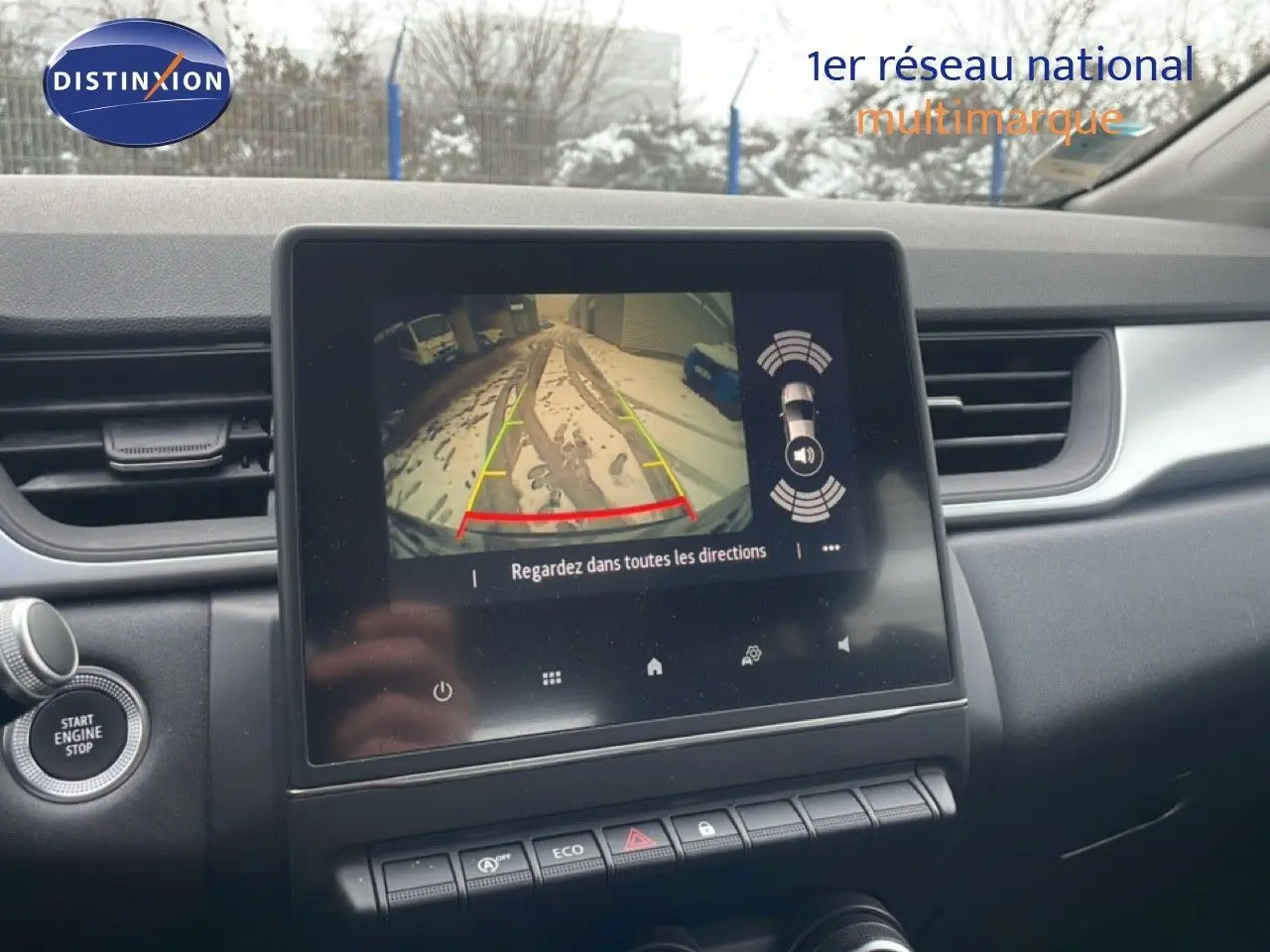 Vue intérieure du tableau de bord du Renault Captur gris Cassiopée, avec écran tactile affichant la caméra de recul.