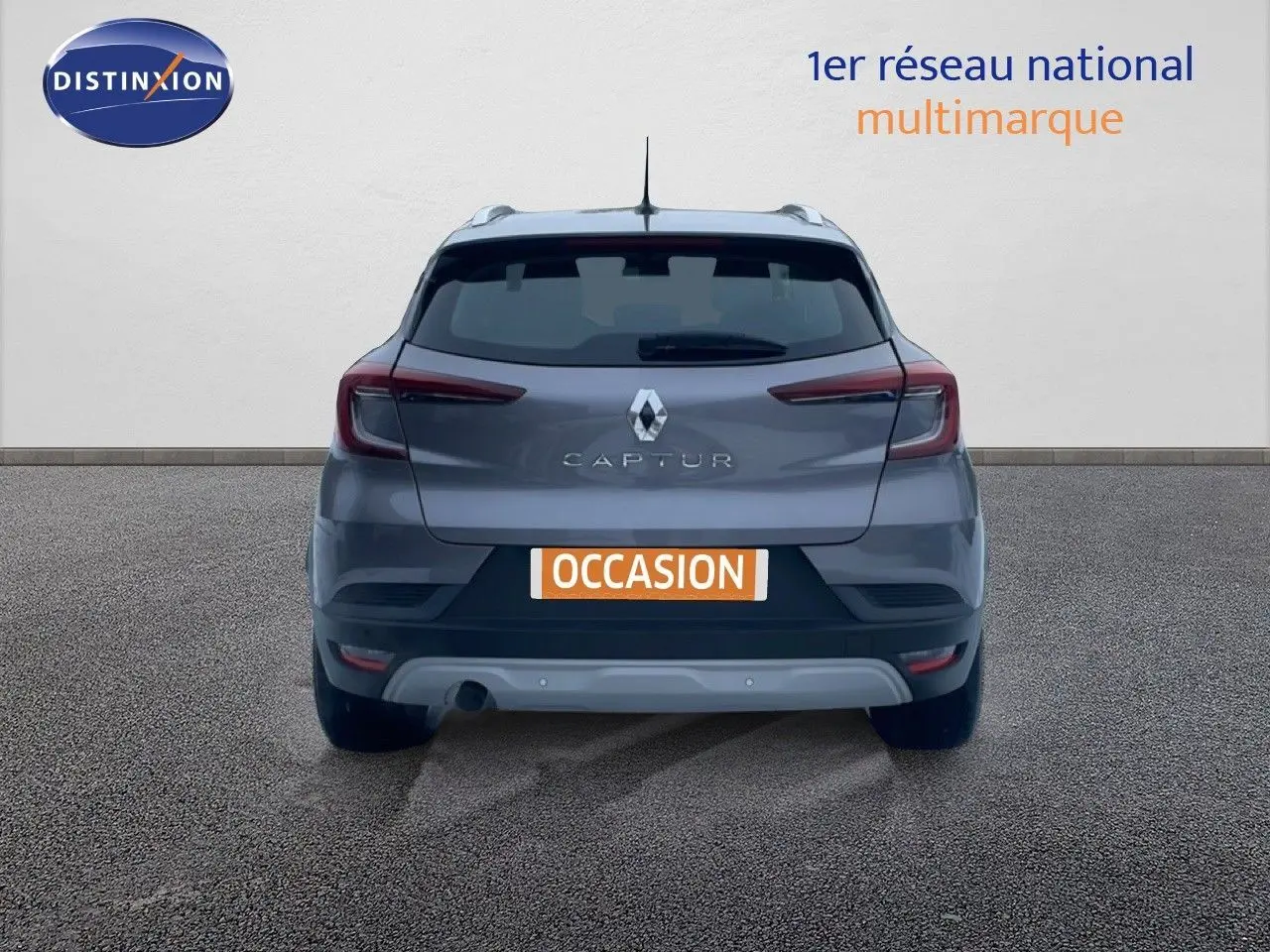 Vue arrière d'un Renault Captur gris cassiopée métal, avec feux arrière allongés et plaque "OCCASION" visible.