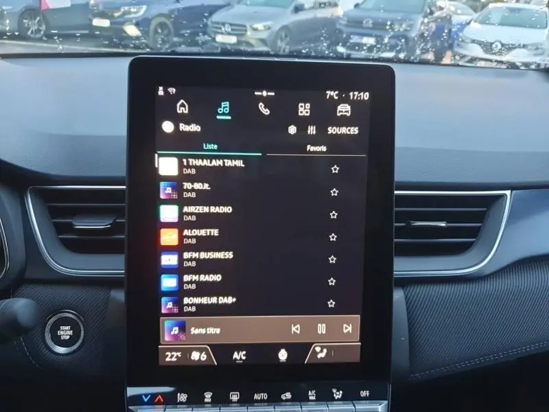 Vue intérieure centrée sur l'écran tactile du tableau de bord du Renault Captur Bleu Iron 2025, avec démarrage sans clé visible.