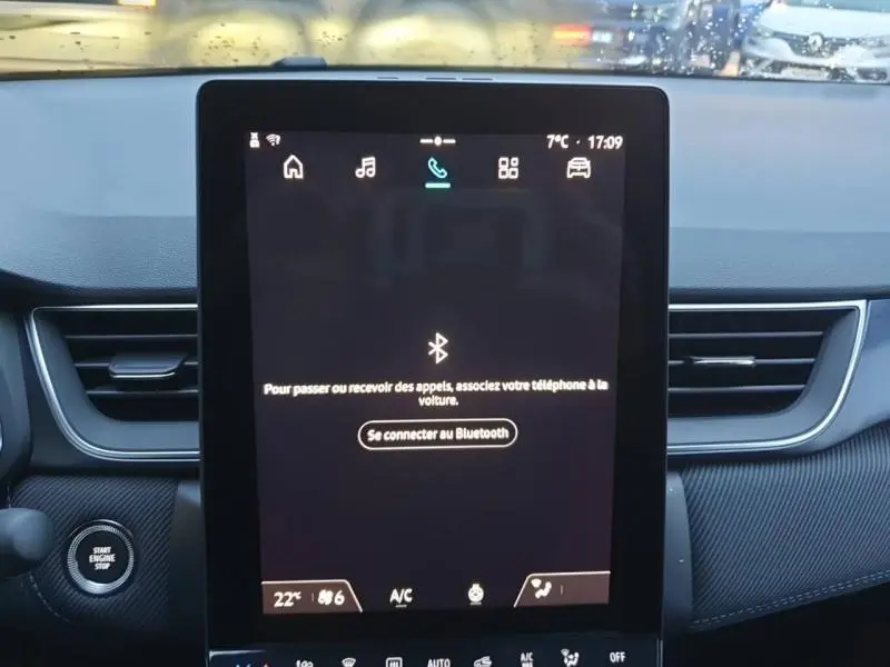 Écran tactile central du Renault Captur 2025 en vue frontale, avec interface Bluetooth et tableau de bord noir.