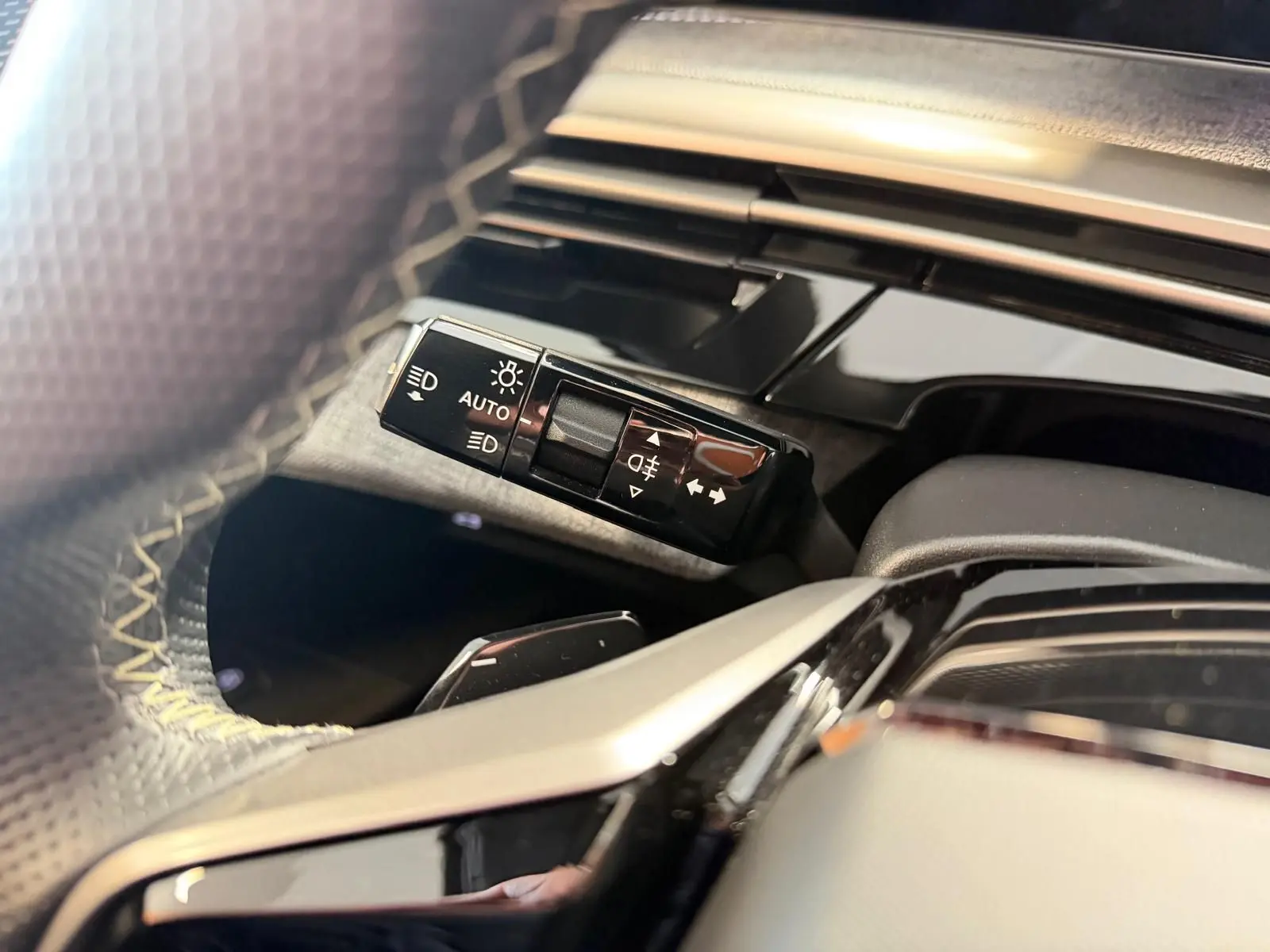 Gros plan sur la commande des feux et clignotants côté gauche du volant du Peugeot 5008 Hybrid 145 GT 2025.