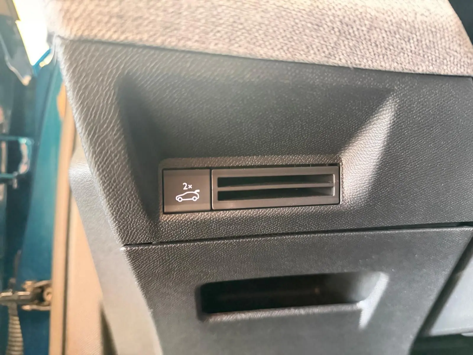 Détail du bouton d'ouverture du hayon électrique sur la porte côté gauche d'un Peugeot 5008 Hybrid 145 bleu obsession.