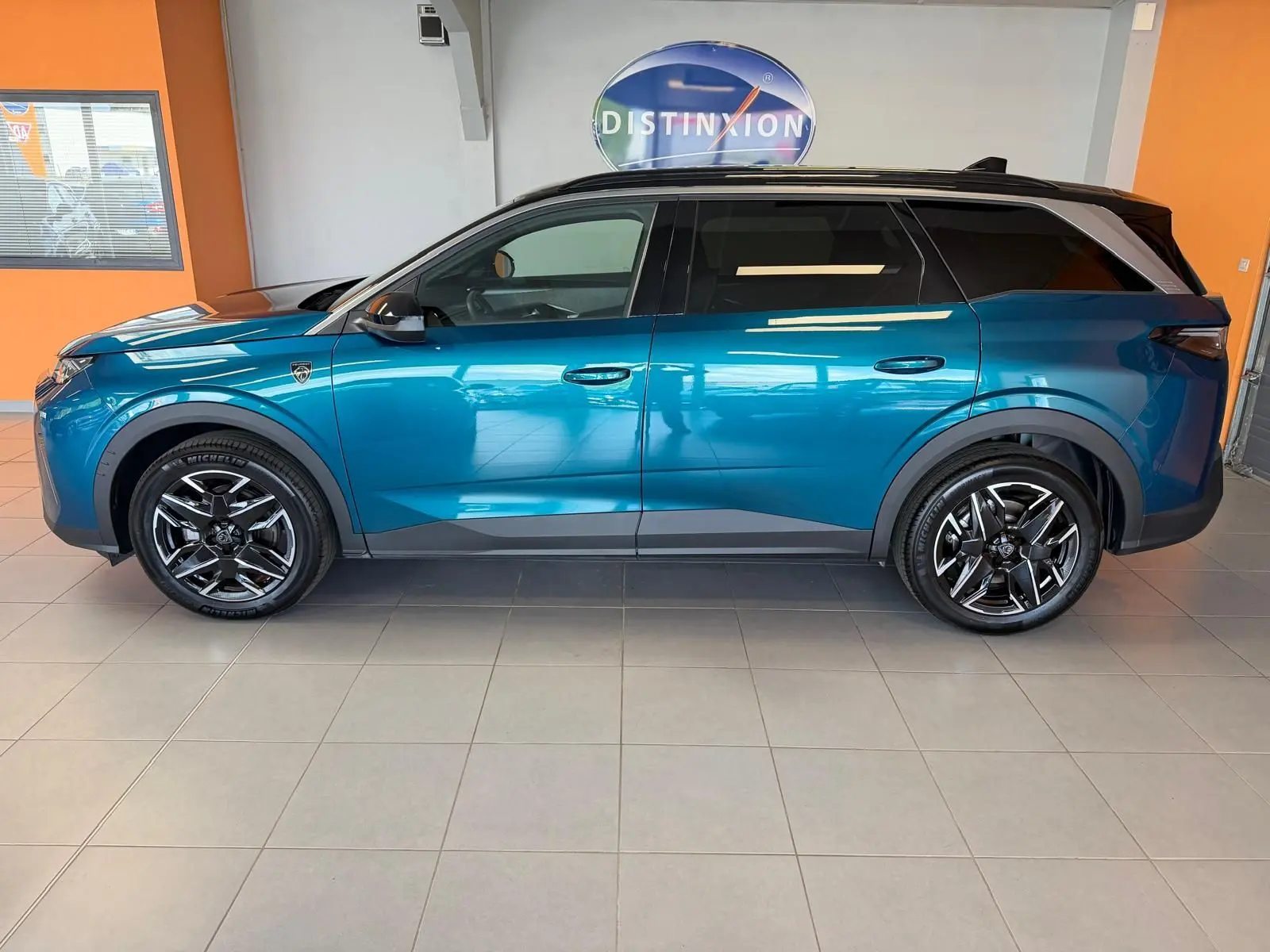 Profil droit du Peugeot 5008 HYBRID 145 GT 2025 en bleu obsession avec toit noir et jantes alliage 19 pouces.