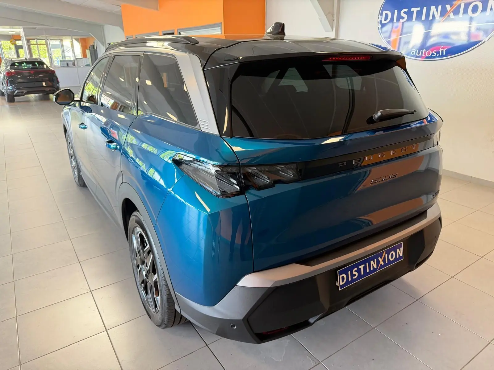 Vue 3/4 arrière droite du Peugeot 5008 Hybrid 145 GT bleu Obsession avec toit noir et jantes alliage 19 pouces.