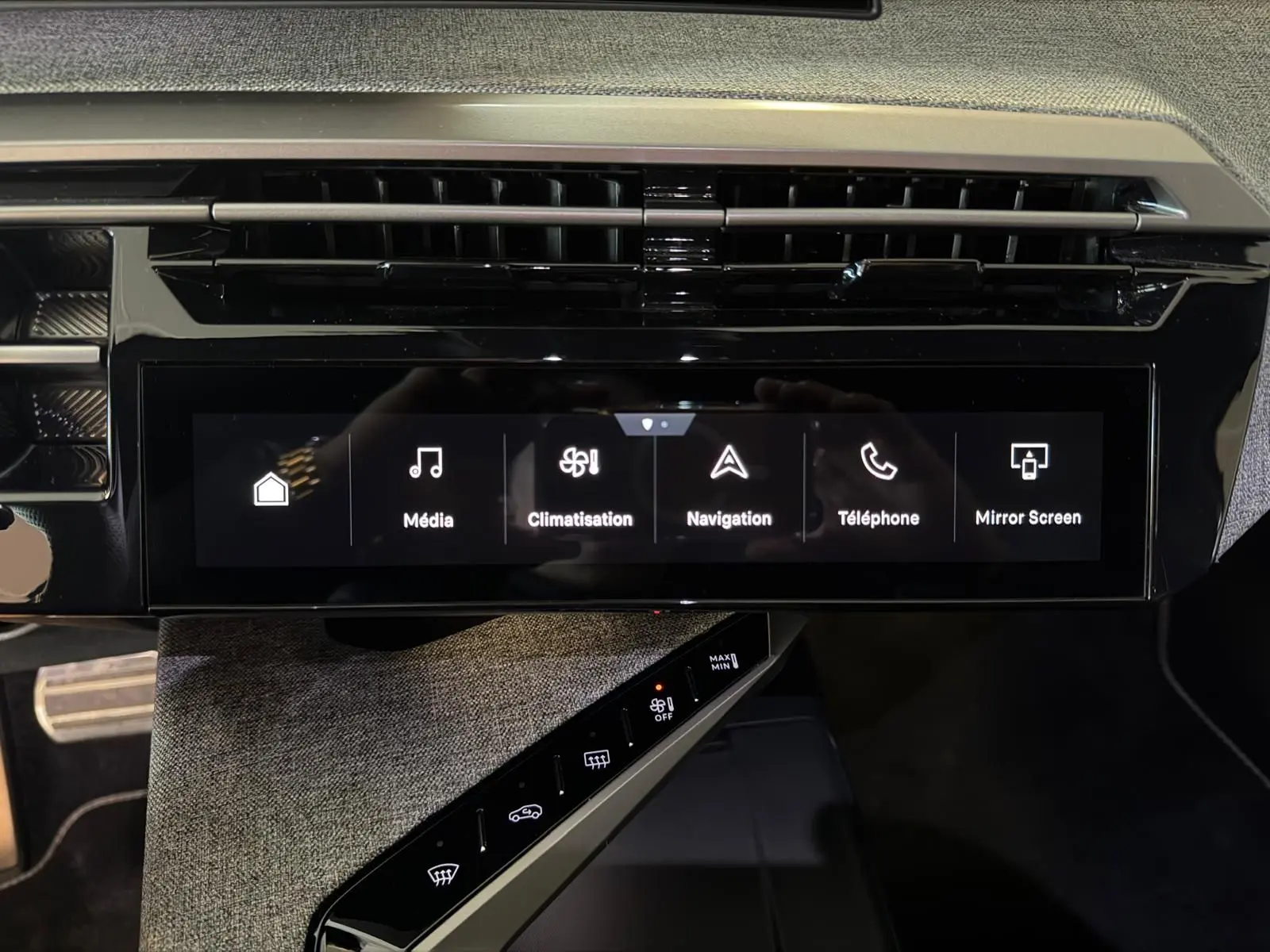 Écran tactile central du Peugeot 5008 Hybrid 145 e-DCS6 GT 2025 avec commandes multimédia et climatisation, intérieur tissu gris.