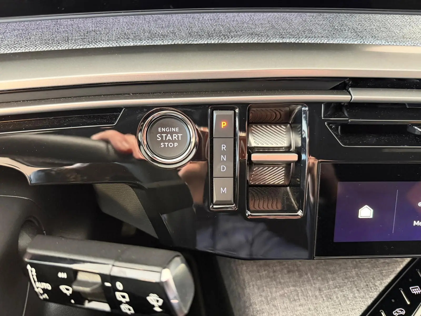 Gros plan intérieur sur la console centrale du Peugeot 5008 Hybrid 145 GT, avec bouton Start/Stop et sélecteur de vitesses.