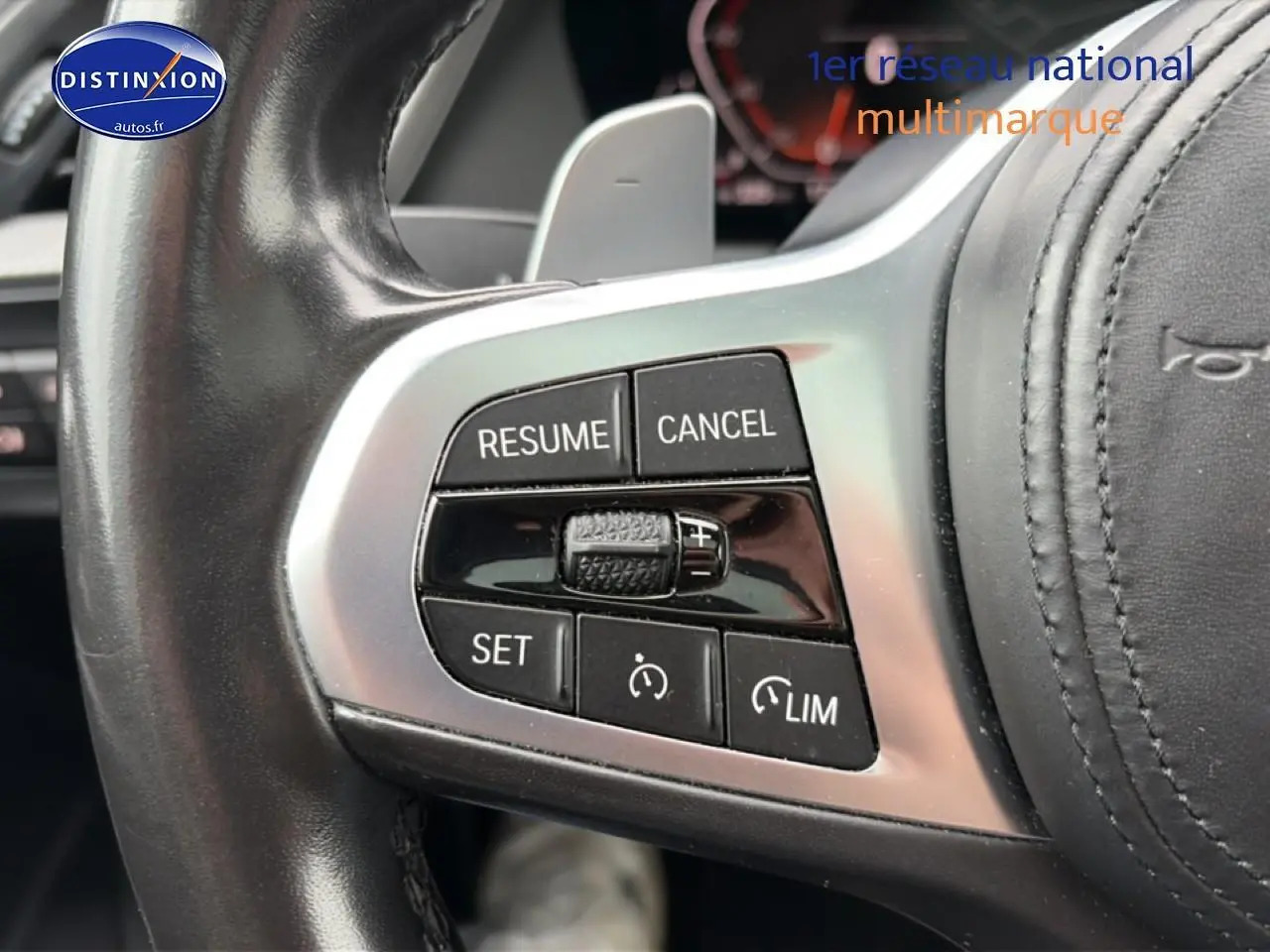 Gros plan sur les commandes du volant cuir noir de la BMW Série 2 Gran Coupé F44, boutons de régulateur de vitesse visibles.
