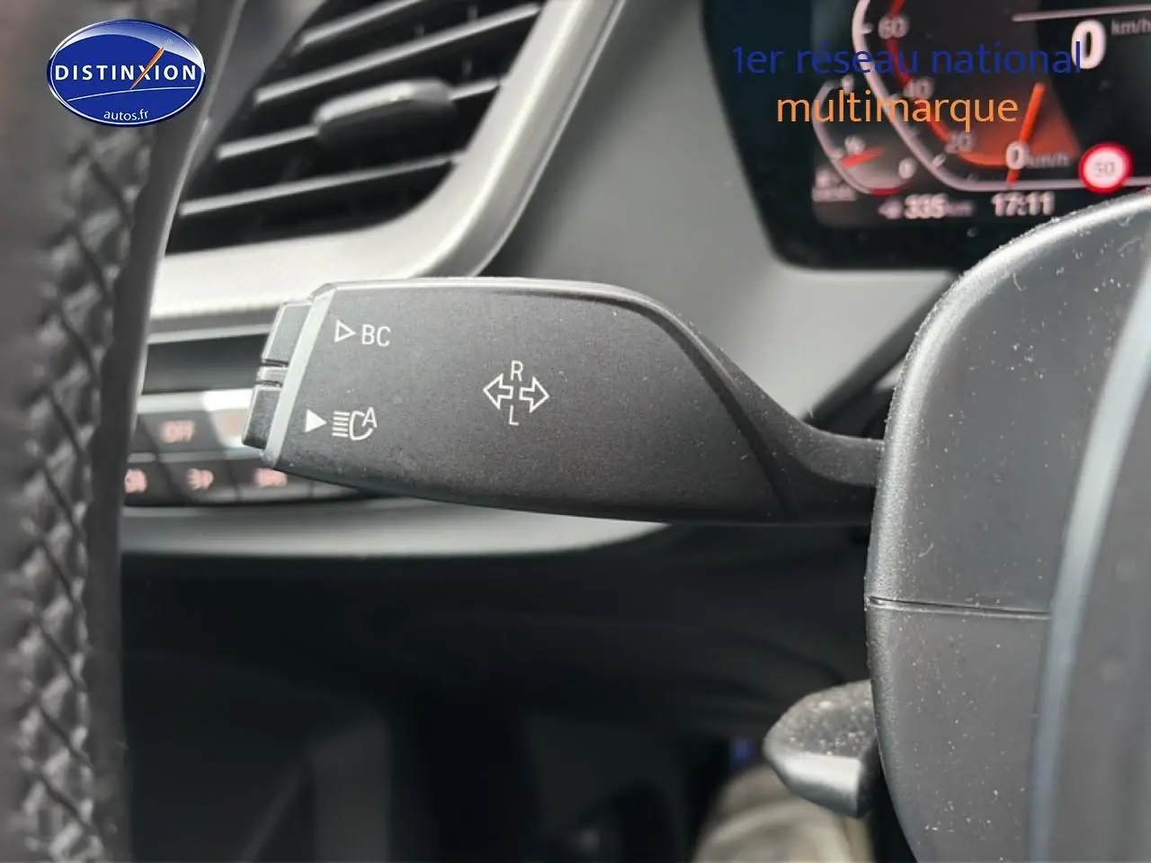 Gros plan sur la commande de clignotant à gauche du volant dans l’habitacle d’une BMW Série 2 Gran Coupe gris 2021.