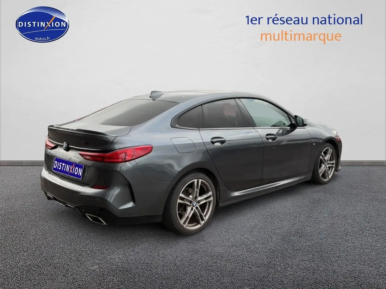 BMW Série 2 Gran Coupe gris vue 3/4 arrière droit avec jantes alu et sorties d'échappement chromées.