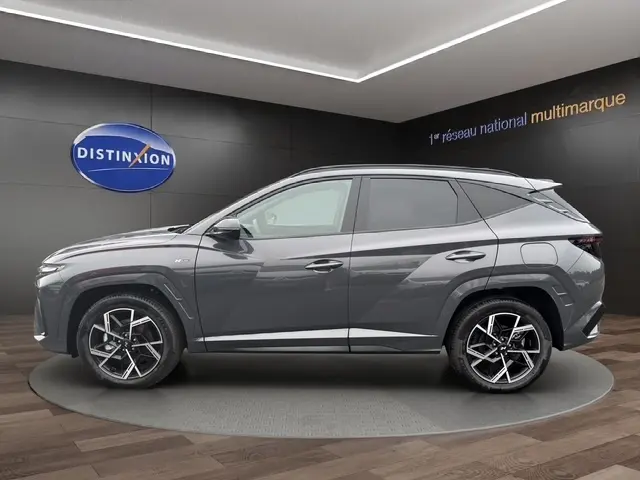 Vue de profil côté gauche d'un Hyundai Tucson 1.6 Hybrid N Line Creative gris foncé avec jantes alliage et hayon motorisé.
