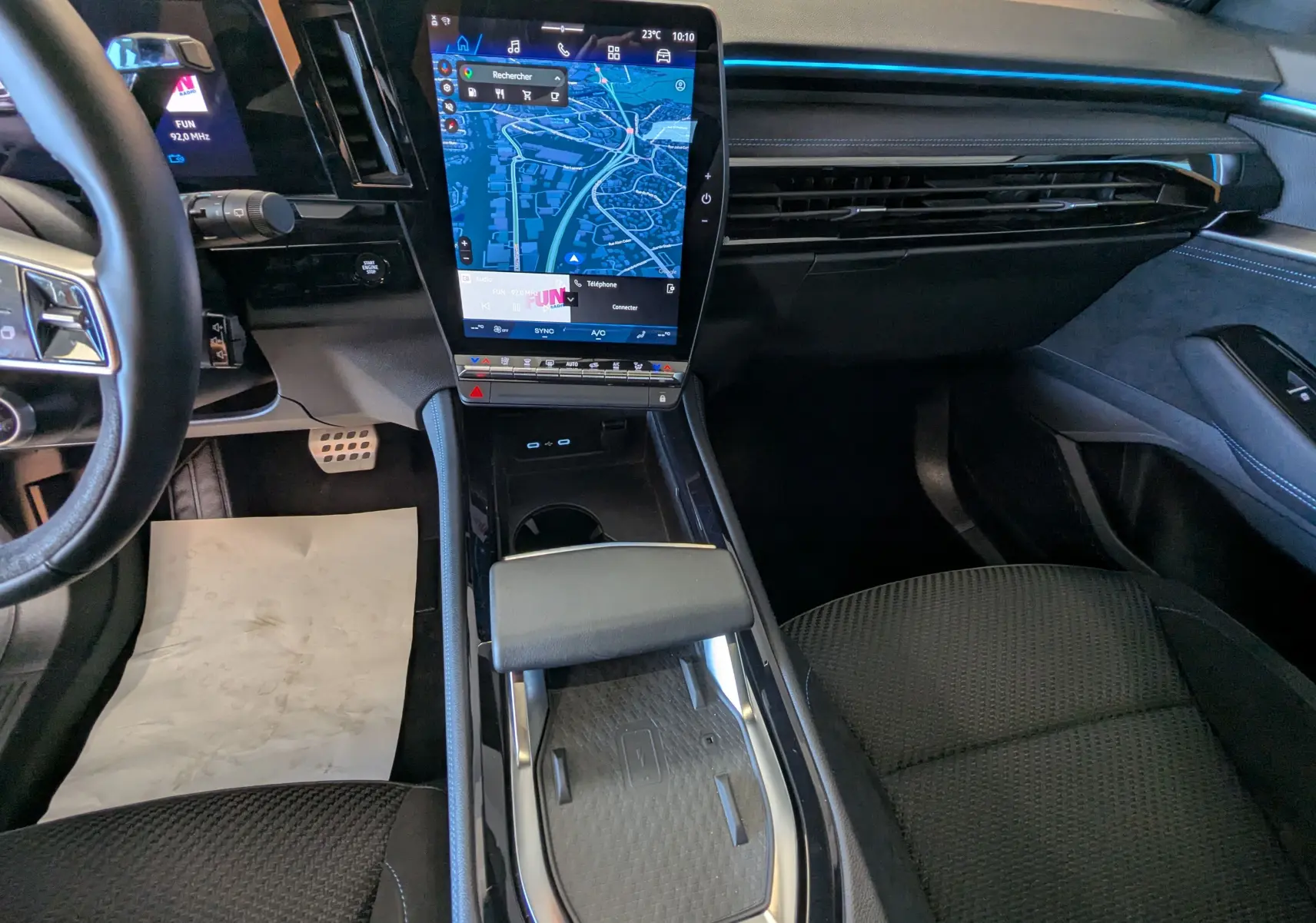 Vue intérieure avant du Renault Espace VI E-Tech noir étoile, avec grand écran tactile central et sièges en tissu noir.