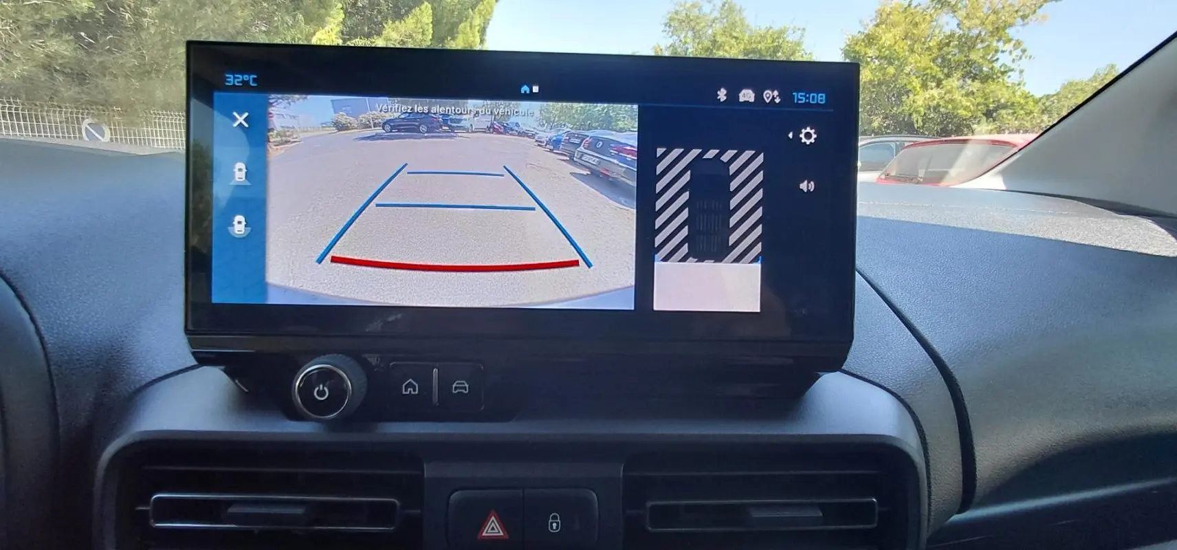 Écran tactile intérieur du Citroën Berlingo 2025 montrant la caméra de recul en plein jour.