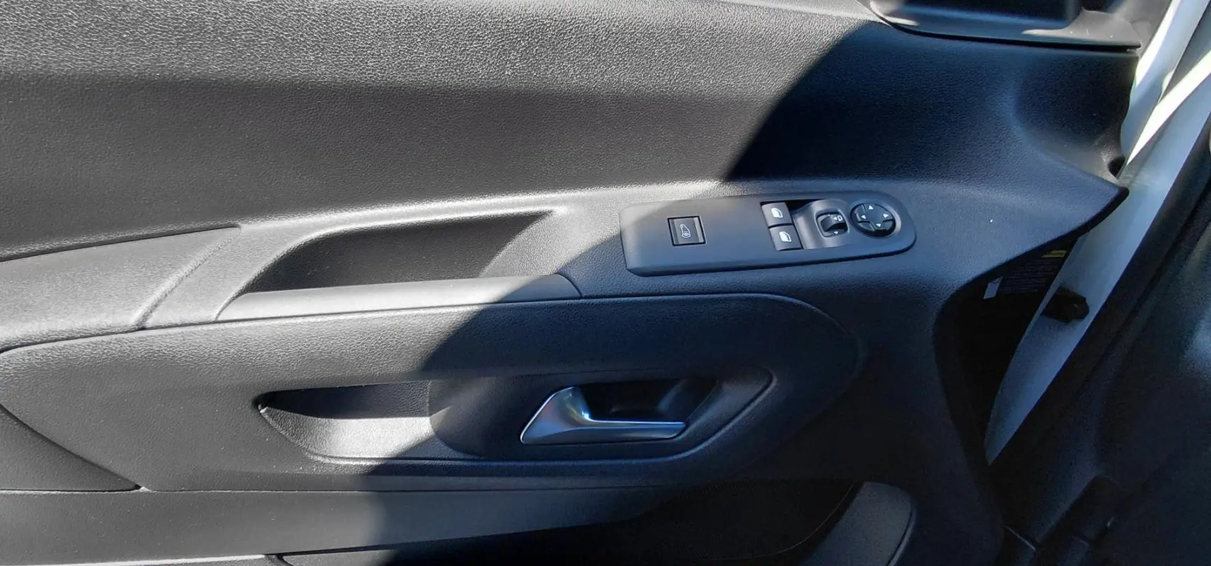 Gros plan sur la porte avant gauche du Citroën Berlingo blanc 2025, avec commandes électriques et poignée intégrée.
