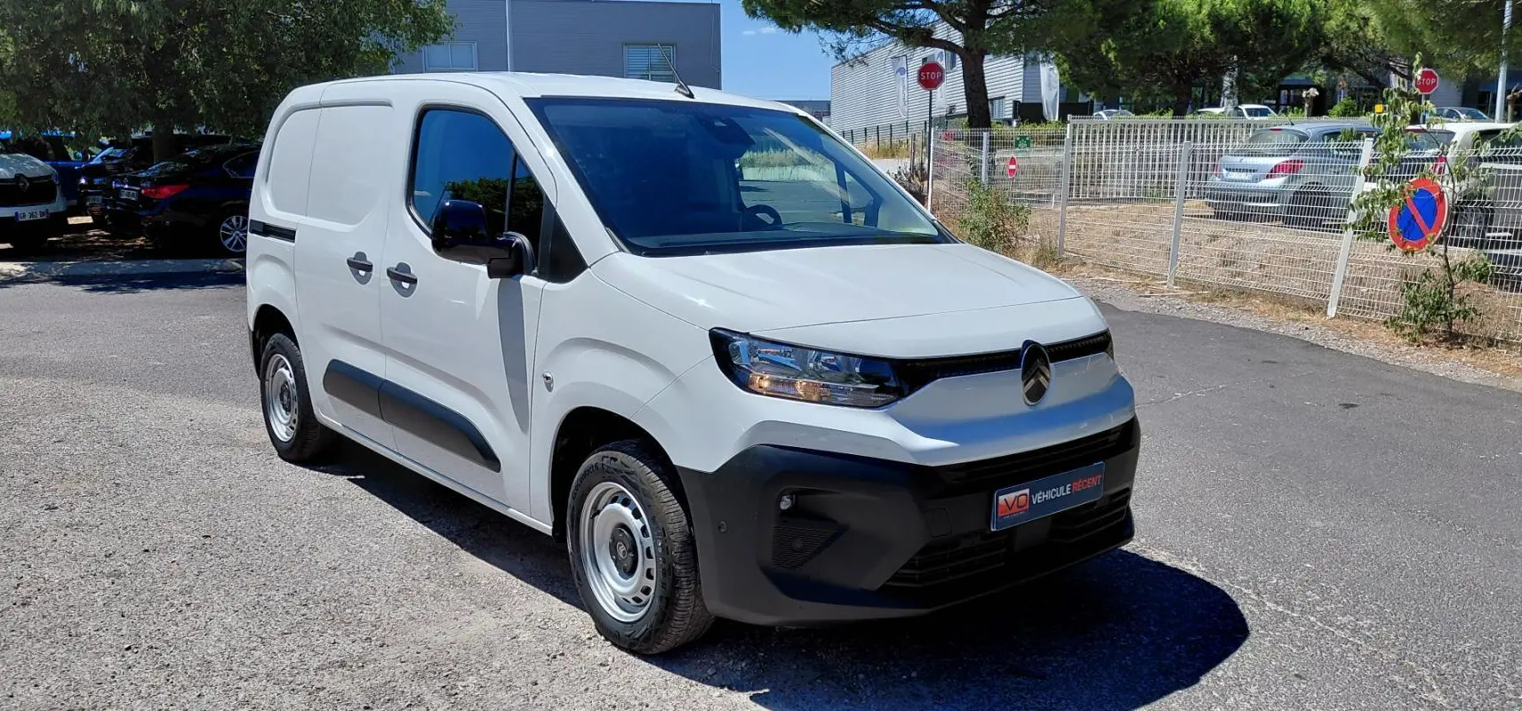 Vue 3/4 avant gauche d’un Citroën Berlingo blanc 2025 avec porte latérale et jantes acier 15 pouces.