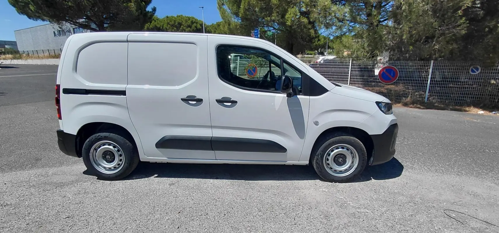 Vue de profil côté gauche d'un Citroën Berlingo blanc 2025, fourgon utilitaire avec porte latérale et jantes acier 15 pouces.