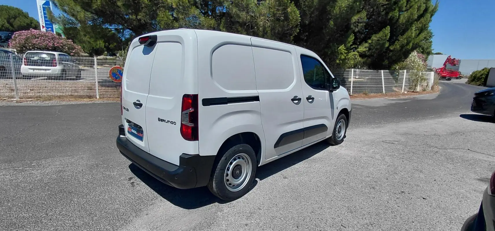 Vue 3/4 arrière droit du Citroën Berlingo blanc 2025 avec porte latérale et jantes acier 15 pouces.