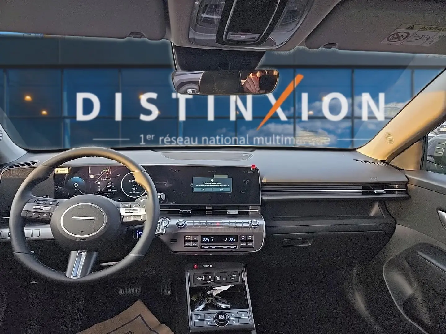 Vue intérieure avant du Hyundai Kona 2025 gris ecotronic, tableau de bord numérique et volant multifonction cuir.