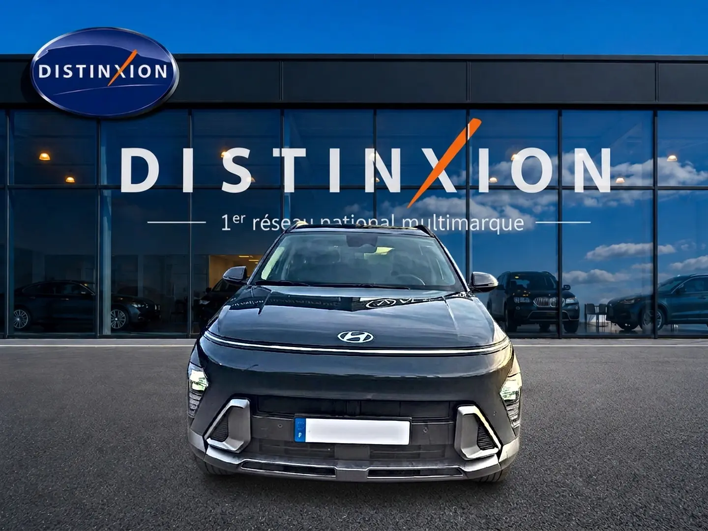 Vue avant d'une Hyundai Kona gris ecotronic avec calandre et feux LED, stationnée devant une vitrine Distinxion.