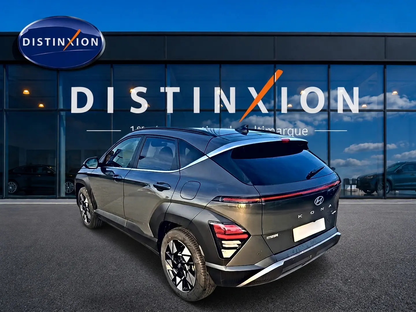 Vue 3/4 arrière droite d’un Hyundai Kona 2025 gris ecotronic avec jantes alliage et bande lumineuse arrière LED.