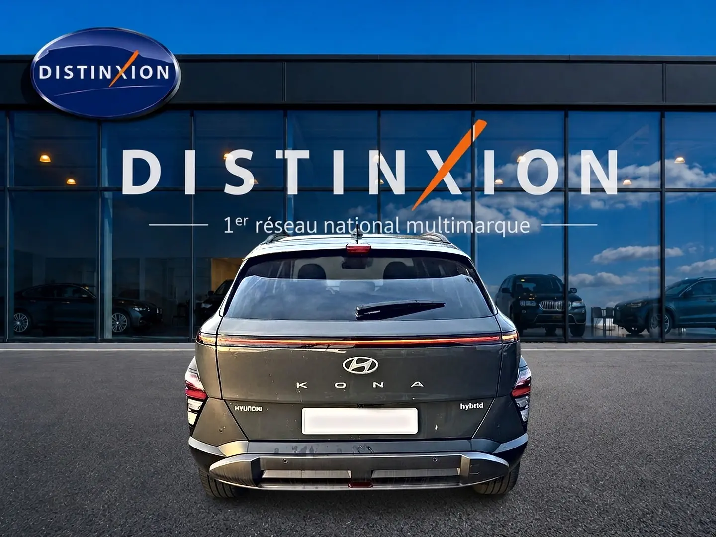 Vue arrière d'un Hyundai Kona hybride gris ecotronic devant une vitrine avec logo Distinxion.
