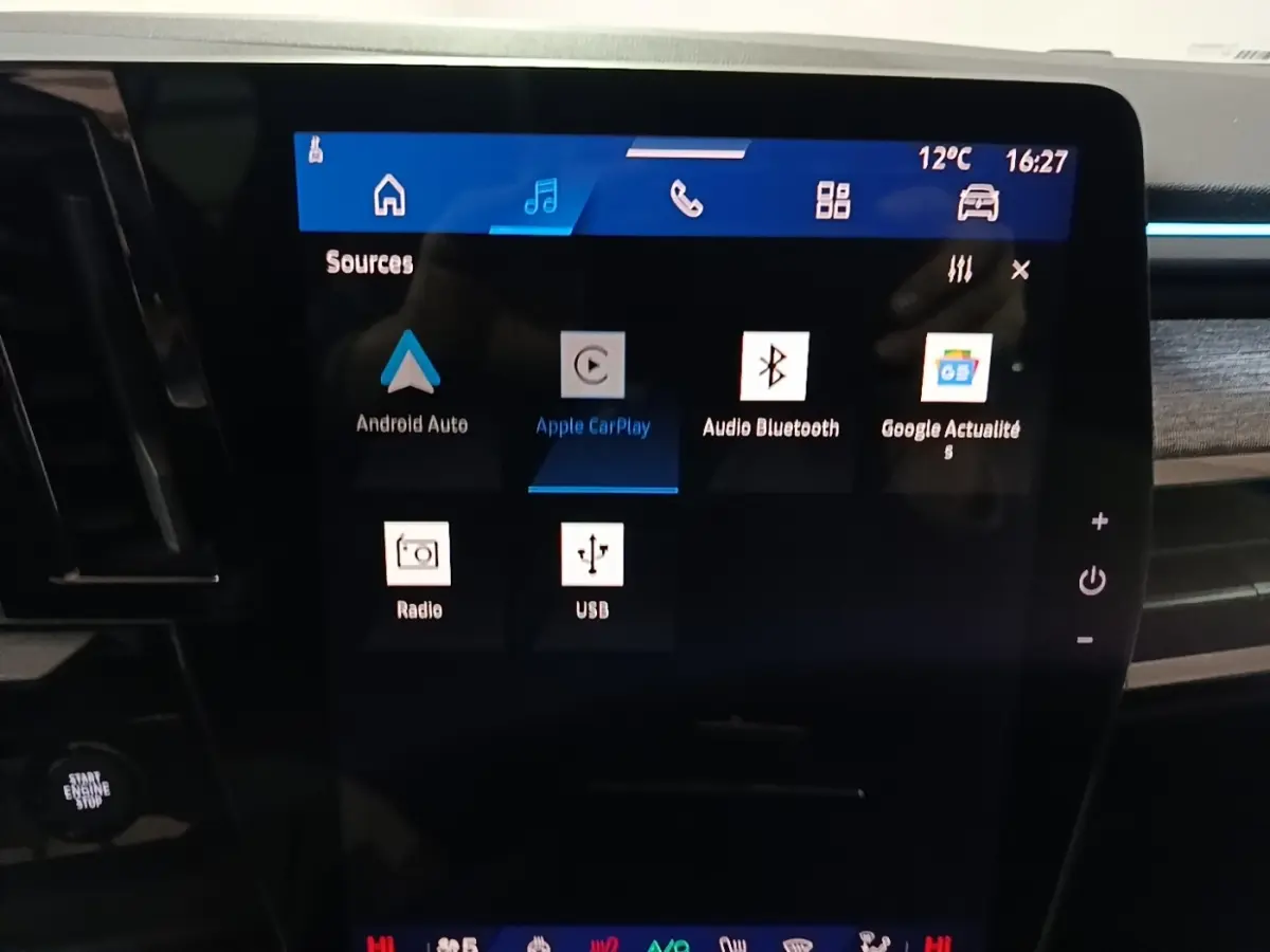 Écran tactile central du tableau de bord du Renault Austral bleu, affichant les options multimédias connectées.