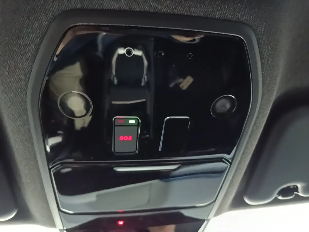 Vue en gros plan du plafonnier intérieur noir du Renault Austral 2024 avec bouton SOS lumineux rouge.