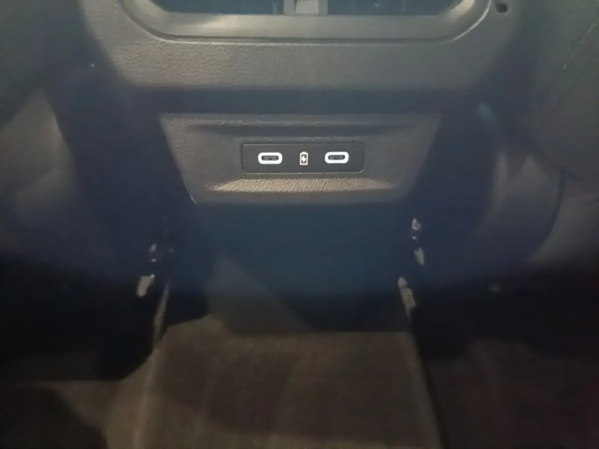 Vue rapprochée des ports USB-C situés à l'arrière de la console centrale du Renault Austral bleu 2024.