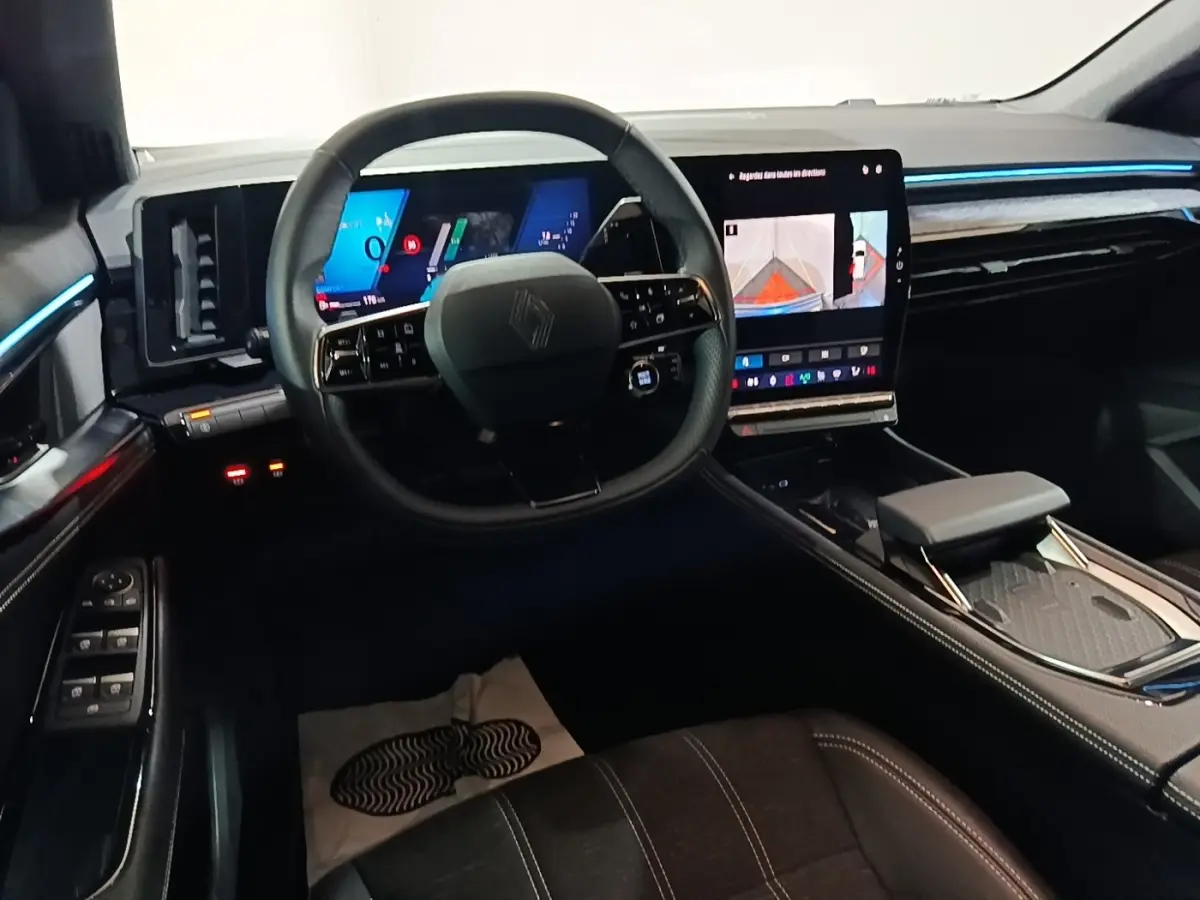 Vue intérieure avant du Renault Austral bleu 2024, volant cuir multifonctions et écran tactile central lumineux.