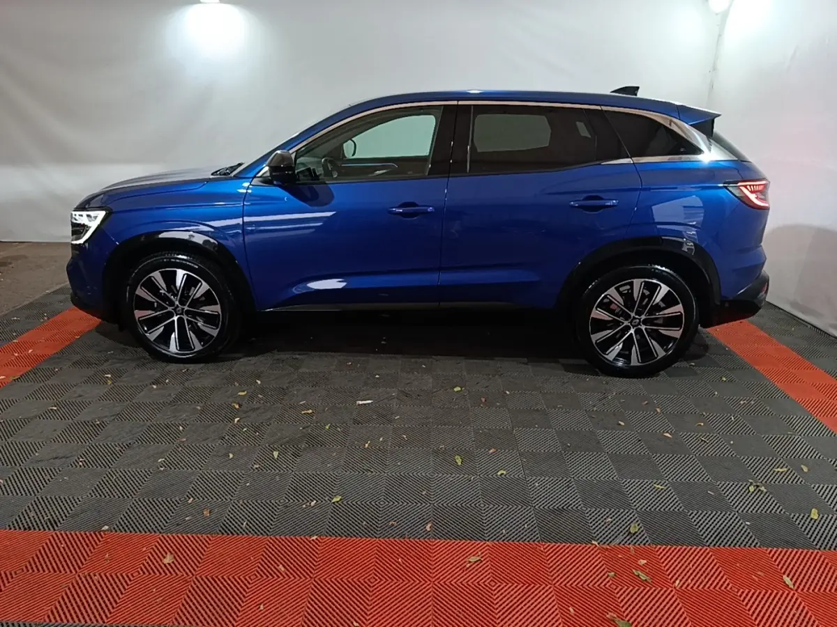 Renault Austral bleu en profil côté gauche, avec jantes alliage noires et toit noir contrasté.