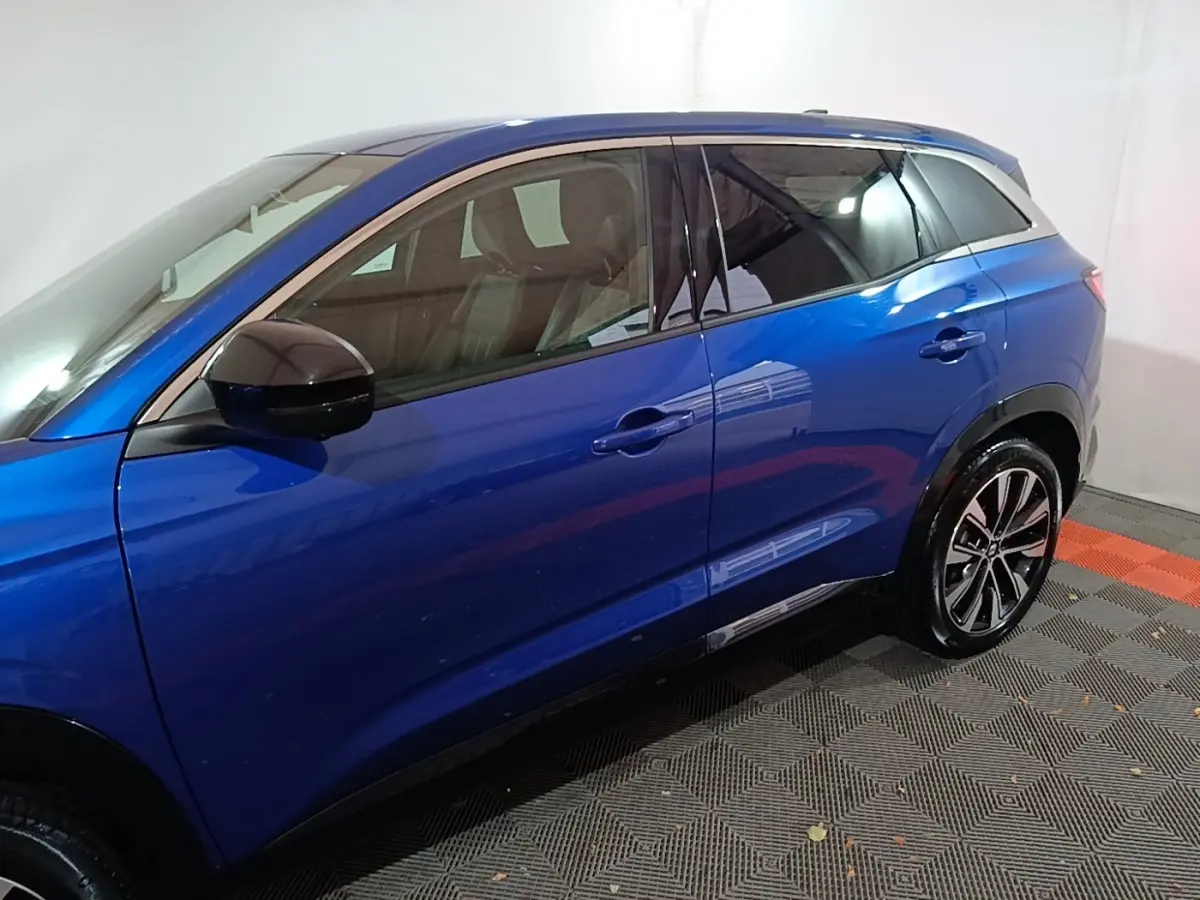 Vue latérale gauche d'un Renault Austral bleu 2024 avec rétroviseurs noirs et jantes alliage bicolores.