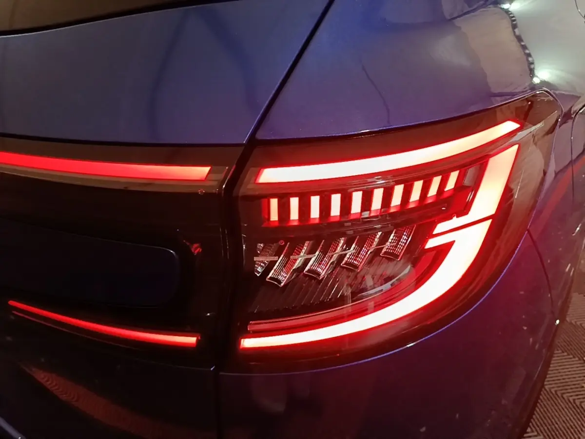 Gros plan sur le feu arrière droit rouge allumé du Renault Austral bleu 2024, soulignant son design lumineux distinctif.