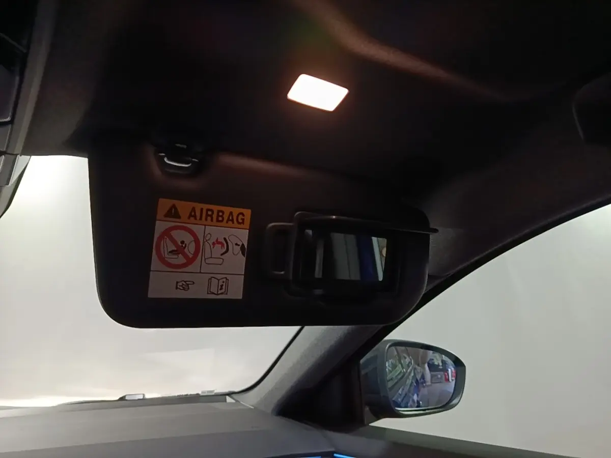 Détail intérieur du pare-soleil côté conducteur avec miroir et avertissement airbag dans un Renault Austral bleu.