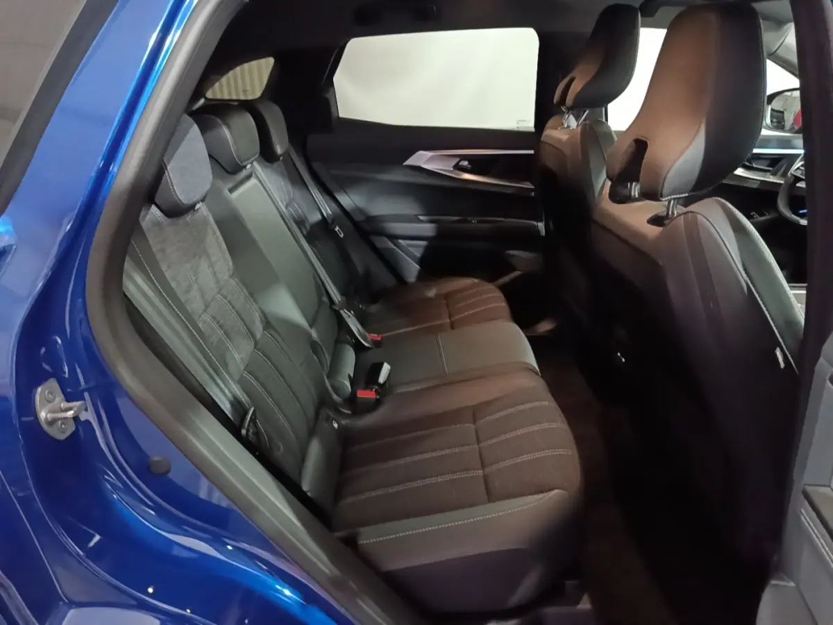 Vue intérieure côté gauche des sièges arrière en tissu noir du Renault Austral bleu 2024, avec détails des appuie-têtes.