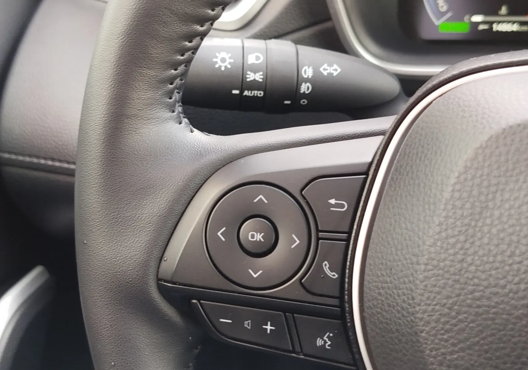 Gros plan sur les commandes au volant à gauche du Toyota Corolla Cross gris acier 2025, avec boutons multifonctions et régulateur.