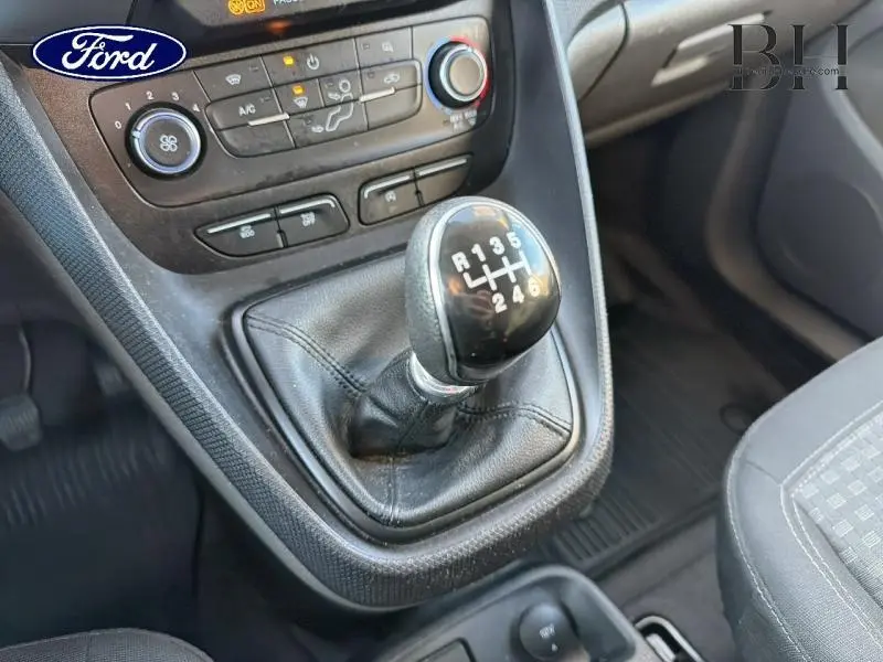 Gros plan sur le levier de vitesses manuel noir et la console centrale du Ford Transit Connect blanc glacier, intérieur avant droit.