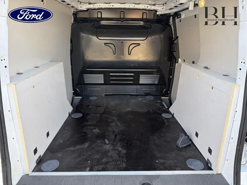 Vue intérieure arrière du Ford Transit Connect blanc glacier, montrant l'espace de chargement avec cloison pleine noire.