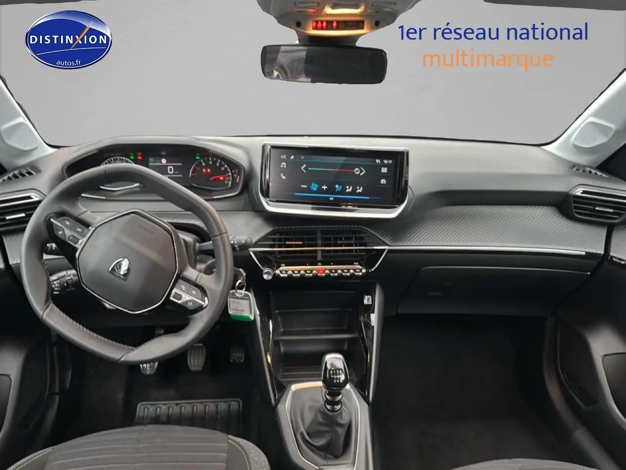Intérieur de Peugeot 208 2024 vue tableau de bord et volant côté gauche, finition gris artense avec écran tactile central.