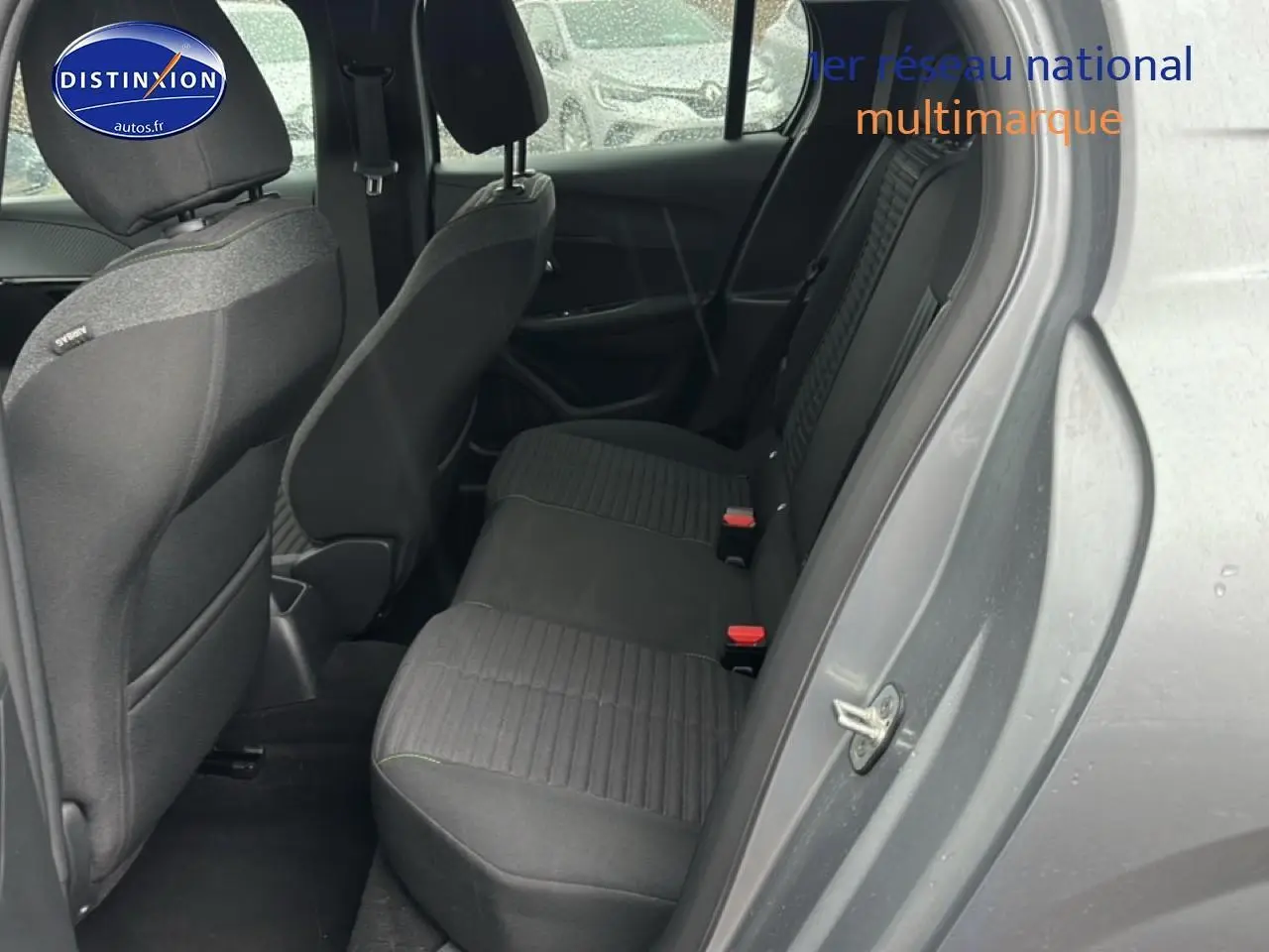 Vue côté droit arrière sur l'intérieur tissu noir/gris de la Peugeot 208 1.2 PureTech 100 Active gris Artense 2024.