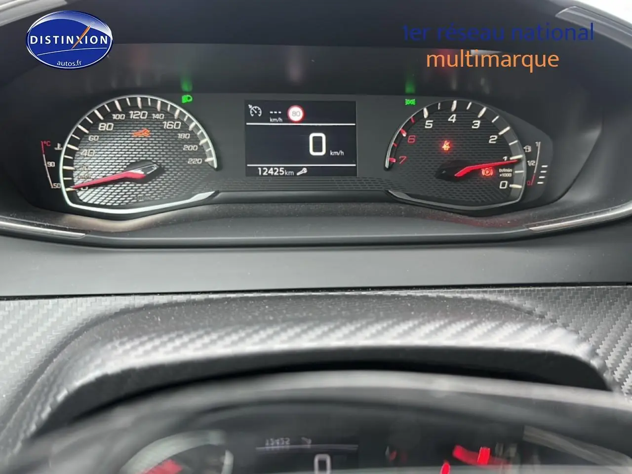 Tableau de bord de Peugeot 208 2024 avec compteur digital et compte-tours en vue frontale rapprochée.