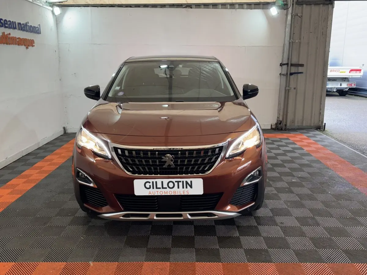 Vue de face d'un Peugeot 3008 orange 2020 avec calandre noire et phares LED allumés en intérieur.