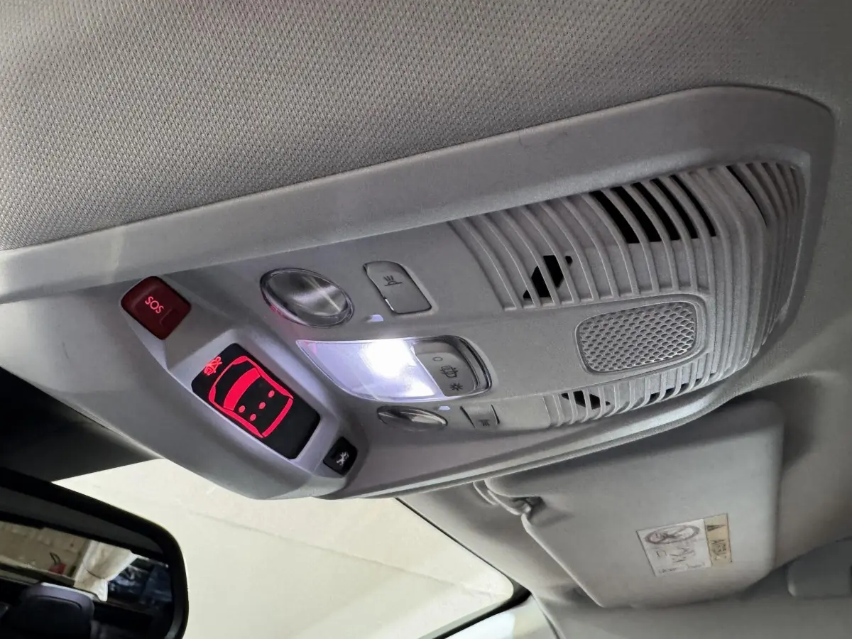Vue intérieure en gros plan du plafonnier gris avec boutons SOS et éclairage, dans un Peugeot 3008 orange 2020.