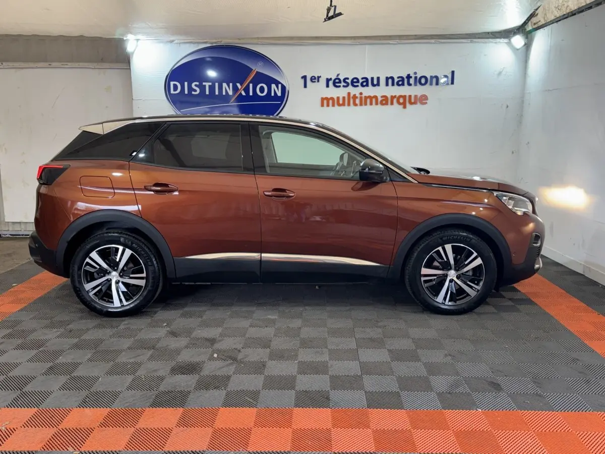 Peugeot 3008 orange vue de profil côté gauche, avec jantes alliage et toit noir contrasté dans un showroom.