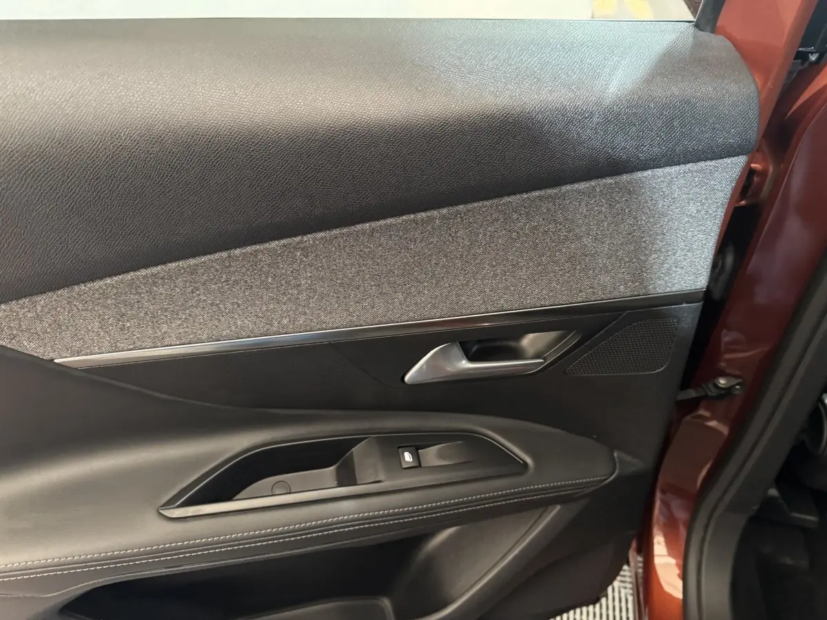 Vue rapprochée de la porte arrière gauche orange du Peugeot 3008 2020, avec garniture noire et tissu gris.