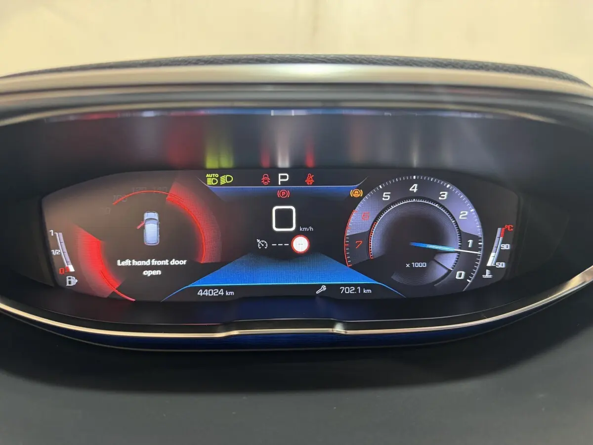 Tableau de bord numérique du Peugeot 3008 PureTech 130, affichant porte avant gauche ouverte et compte-tours bleu.