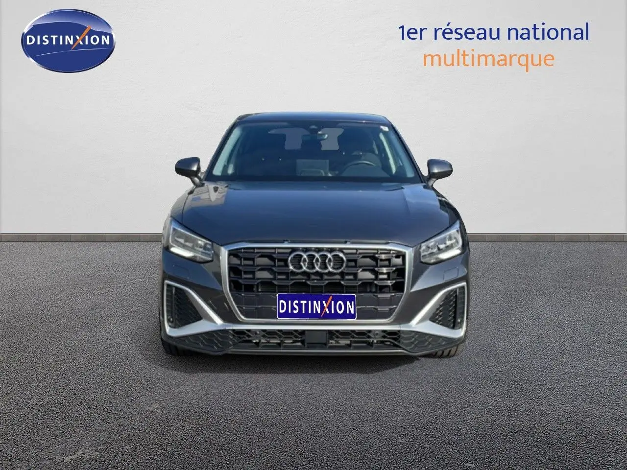 Vue frontale d'un Audi Q2 30 TDI S-Line gris Manhattan métallisé, avec calandre large et phares LED distinctifs.