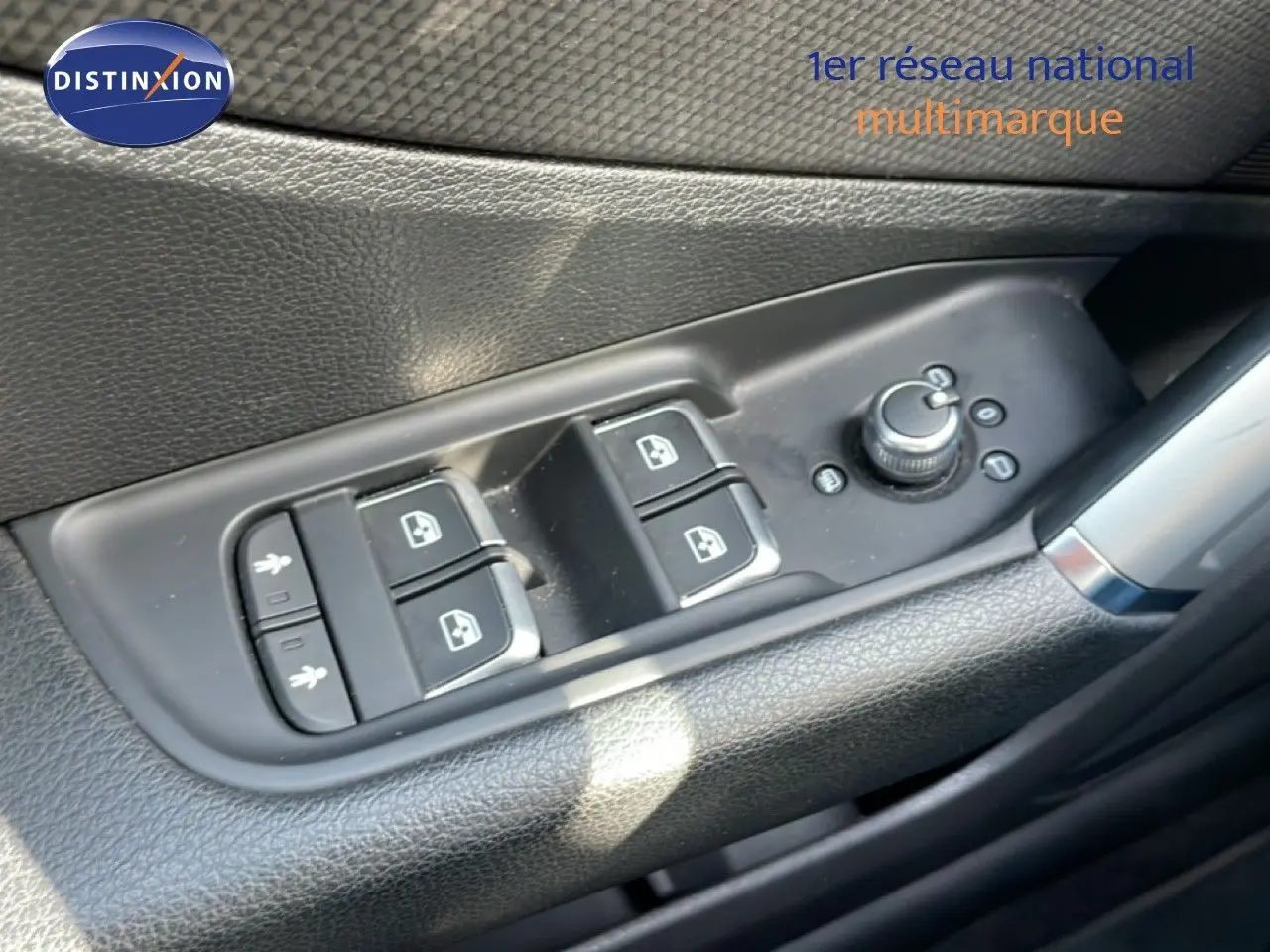 Gros plan sur les commandes des vitres et rétroviseurs côté conducteur d’un Audi Q2 gris Manhattan 2025.